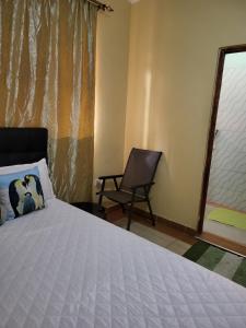- une chambre avec un lit, une chaise et une fenêtre dans l'établissement G&G Westindies Executive One Bedroom, à Eldoret