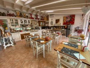 una cocina con mesas y sillas en una habitación en Romantica camere Le Fate con Vista sulle Montagne vicino a Bassano del Grappa, en Romano D'Ezzelino