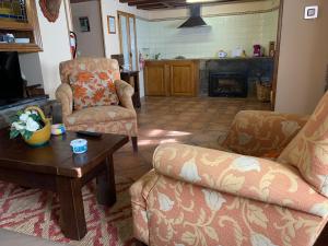 a living room with two chairs and a coffee table at El Corral de Baxo in Felechosa