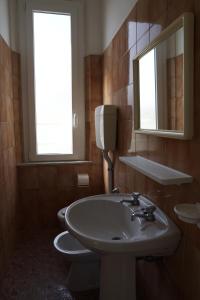 y baño con lavabo, aseo y espejo. en Hotel Aurora Nord, en Rímini