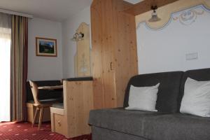 a living room with a couch and a desk at Appartments Jägerhof in Valdaora