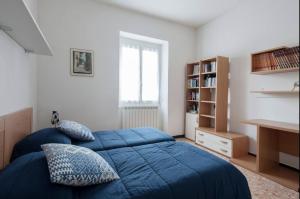 a bedroom with a blue bed and a book shelf at I Venti in Levanto