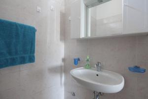 ein Badezimmer mit einem Waschbecken, einem Spiegel und einem blauen Handtuch in der Unterkunft I Venti in Levanto