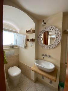 マテーラにあるLa Bomboniera Holiday Homeのバスルーム(洗面台、トイレ、鏡付)