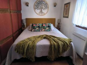 Un dormitorio con una cama con una manta. en Appartements - 1 mn du centre, en Ribeauvillé