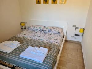 a small bedroom with a bed with towels on it at Villa caposchiera a 500 metri dal mare in Villasimius