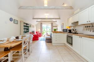a kitchen and dining room with a table and a kitchen and a living room at Thyme Cottage in Eastdean