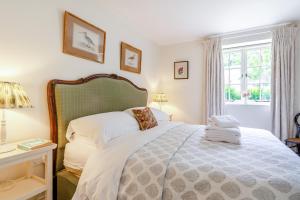 a bedroom with a bed and a window at Thyme Cottage in Eastdean