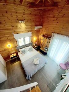 a bedroom with a white bed and a wooden wall at Divine Studios Elafonisos B2 in Elafonisos