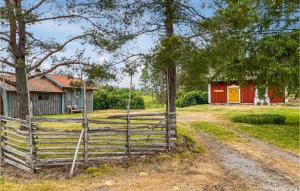 une clôture devant une grange rouge dans l'établissement Beautiful Home In Valdemarsvik With Sauna, à Valdemarsvik