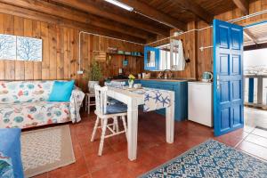 a kitchen and living room with a table and a couch at Cabin in front of idyllic majanicho beach in Majanicho