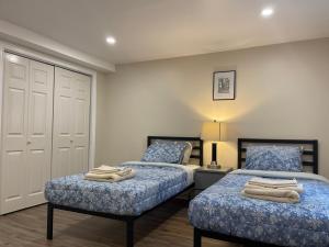 um quarto com 2 camas com lençóis azuis e brancos em Katie entire basement 3 bedrooms em Charlottetown