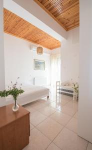 una camera con letto e soffitto in legno di Vaios Villa LakeView a Ágios Athanásios