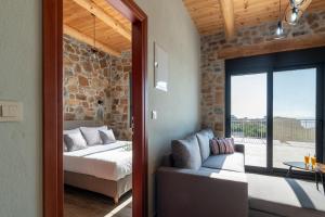 a bedroom with a bed and a couch and a window at The Rock *Peaceful Retreat House in Kámbos +38 photos