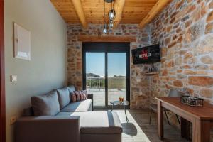 a living room with a couch and a stone wall at The Rock *Peaceful Retreat House in Kámbos