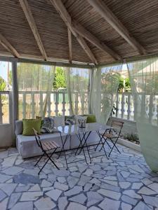 a living room with a couch and a table and chairs at Golden Beach-Tsianis Apartments in Nea Mesangala