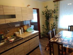 a kitchen with a sink and a table with a dining room at Erdei Vendégház in Nagyesztergár