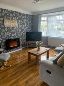 a living room with a couch and a fireplace at Hafan Traeth in Prestatyn
