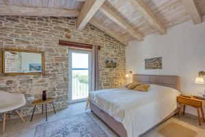 a bedroom with a bed and a stone wall at Villa 4 Flowers in Selina +42 photos