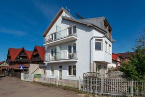 a white house with red roofs at pensjonat Alka in Jastarnia