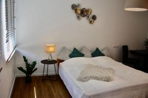 - une chambre avec un lit blanc et des oreillers verts dans l'établissement 3,5 Zimmer Wohnung nahe Legoland, à Neuburg an der Kammel