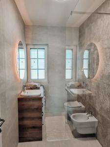 a bathroom with two sinks and a toilet and mirrors at STONE HOUSE JEZERA in Jezera