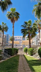 een gebouw met palmbomen ervoor bij Apartamento Denia Elegance Las Marinas in Denia