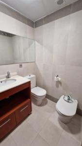 een badkamer met een wastafel, een toilet en een spiegel bij Apartamento Denia Elegance Las Marinas in Denia