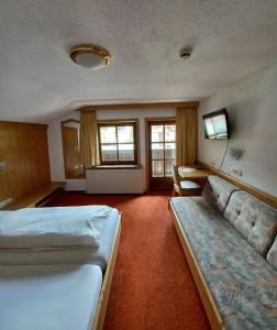 une chambre d'hôtel avec deux lits et un canapé dans l'établissement Hotel Restaurant Liesele Sonne, à Sankt Leonhard im Pitztal