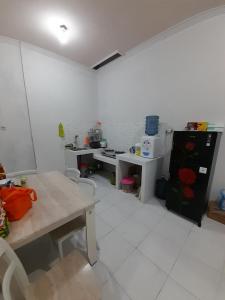 uma pequena cozinha com uma mesa e um frigorífico em Bumi Dieng Indah Residence em Kalianget