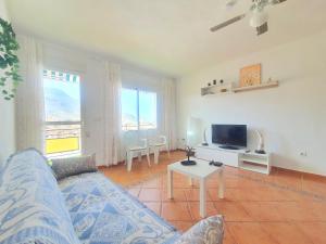 uma sala de estar com um sofá e uma televisão em Apartamento en Calabardina - by Aloha Palma em Calabardina
