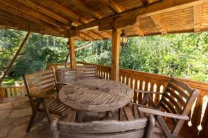 a wooden table and chairs on a porch at Eco Hotel Imenieto in Emen