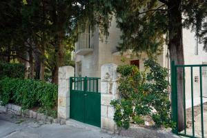 a green gate in front of a house with trees at Villa Linda in Split