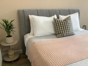 una cama con almohadas blancas y una planta en ella en Gina’s studio. en Bistriţa