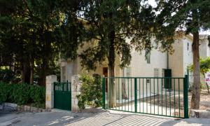 um portão verde em frente a uma casa com árvores em Villa Linda em Split