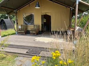 a porch of a tent with chairs and flowers at FF uutbloazen in Heelweg