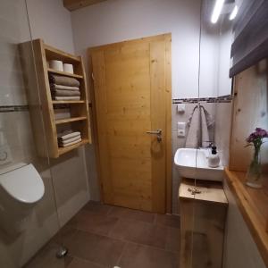 a bathroom with a sink and a wooden door at Ferienwohnung Morgenrot in Pfronten