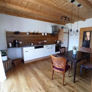 a kitchen with white cabinets and a table and chairs at Ferienwohnung Morgenrot in Pfronten +16 photos