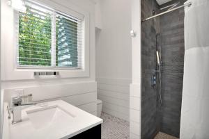 uma casa de banho branca com um lavatório e um chuveiro em The Surf Club Resort em Montauk