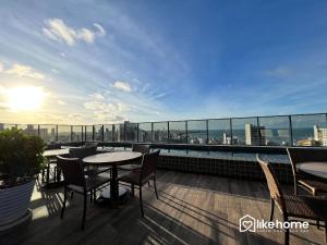 een balkon met tafels en stoelen en uitzicht op de stad bij One Way in João Pessoa