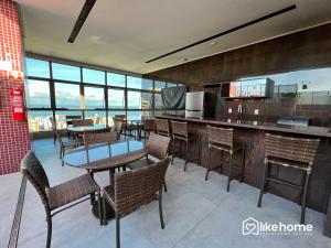 a restaurant with tables and chairs and a kitchen at One Way in João Pessoa