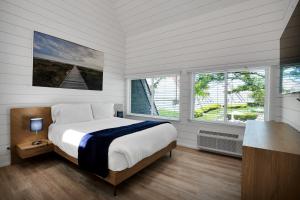 a bedroom with a large bed and two windows at The Surf Club Resort in Montauk +289 photos