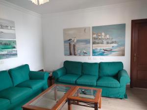 ein Wohnzimmer mit einem grünen Sofa und einem Couchtisch in der Unterkunft Come Together in San Juan de la Rambla