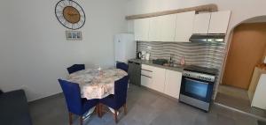 eine kleine Küche mit einem Tisch und einem Herd in der Unterkunft Blue Sea in Pirovac