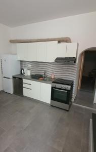 eine Küche mit weißen Schränken und einem Herd mit Backofen in der Unterkunft Blue Sea in Pirovac + 5 Fotos