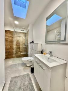 La salle de bains blanche est pourvue de toilettes et d'un lavabo. dans l'établissement Erholsame City-Erdgeschosswohnung mit Veranda, Grill und Parkplatz D46EG, à Oldenbourg