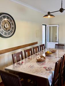 L'Escale au Portugal Villa-B&B-Spa في Ataíja de Baixo: طاولة غرفة طعام مع ساعة كبيرة على الحائط