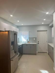 a kitchen with a stainless steel refrigerator and a door at Flowealth Property in Toronto