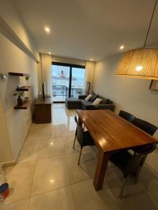 a living room with a wooden table and a couch at Liniers, con vista al mar in Mar del Plata