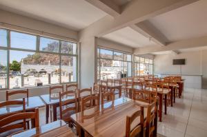 a restaurant with wooden tables and chairs and windows at Lapa Hotel in Bom Jesus da Lapa